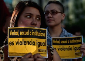 Activists hold signs reading "Verbal, sexual or institutional, it is violence anyway" as they take part in a pro-abortion demo in front of La Moneda presidential Palace in Santiago on November 11, 2014. Hundreds of people gathered in Santiago Tuesday in support of abortion. AFP PHOTO/MARTIN BERNETTI (Photo credit should read MARTIN BERNETTI/AFP/Getty Images)