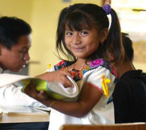 This picture shows a happy little girl getting an education. NGOs and other services try to provide education for street children to help them get out of the life situation the street has provided.